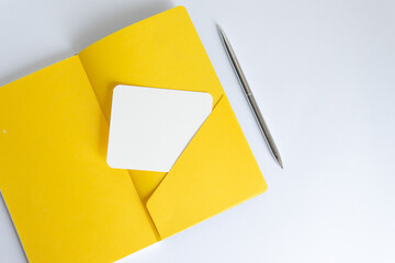 yellow open notebook with a pocket for a note on a white background
