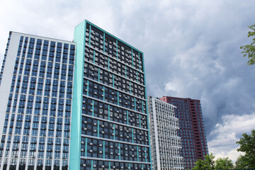 modern buildings in the city of Kyiv, Ukraine with green trees on a blue sky background