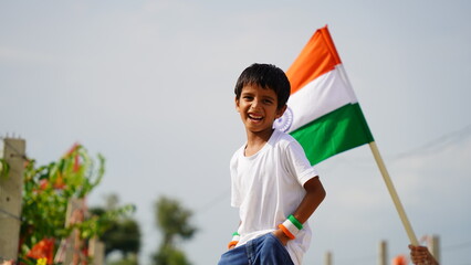 Cute little boy holding Indian flag in his hands and smiling. Celebrating Independence day or...