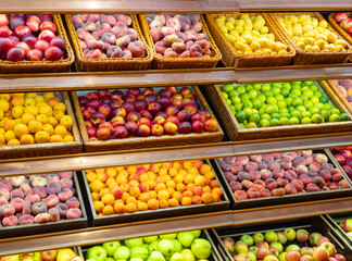Assortment of fresh fruits on store shelves, on market counter.