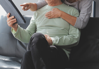 Embraced mature couple surfing the Internet on laptop at home