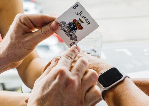 A Magician Sets Up A Magic Trick Using a Joker Card