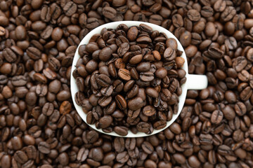 coffee beans in a cup on a coffee bean brown backgroun