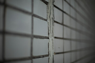 Wall of tiles. Tiles in cladding of building. Wall details.