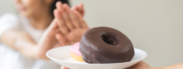 Diet, refuse asian young woman hand push out, deny sugar donut, doughnut and sweet taste food on...