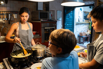 Young girl cooking with family in kitchen