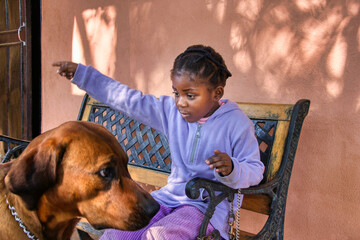 african girl and dog on the bench outdoors, sorry facial expression
