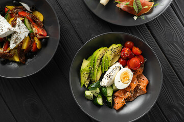 Balanced diet, cooking, culinary and food concept. Ketogenic diet breakfast. Salt salmon salad with avocado, sesame, tomato, cucumber and quail egg. Copy space