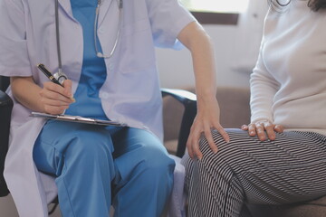 Fototapeta premium Asian doctor woman visited patient woman to diagnosis and check up health at home or private hospital. Female patient explain health problem and symptoms to doctor .Health care premium service at home
