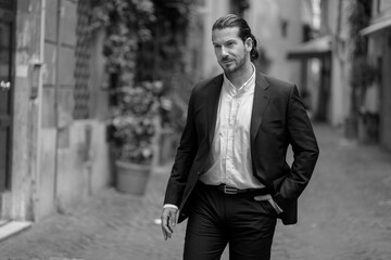 A handsome brunette Spaniard in a classic suit walks through the city