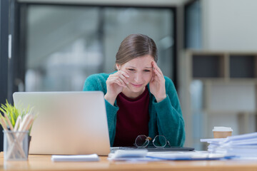 Attractive young office worker holding a  binder as she looks at the camera with a sweet friendly smile