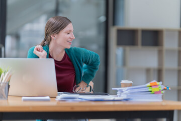 Attractive young office worker holding a  binder as she looks at the camera with a sweet friendly smile