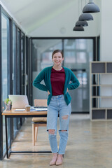 Attractive young office worker holding a  binder as she looks at the camera with a sweet friendly smile