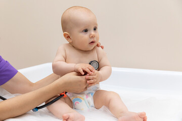 Medical check up. Pediatrician listening to baby's lungs and heart, close up