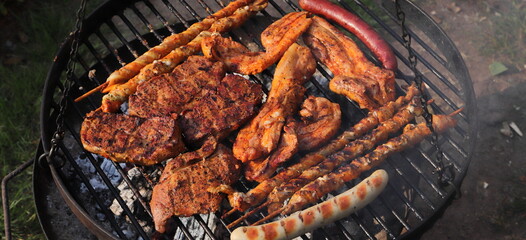 various meat and sausages on the charcoal grill