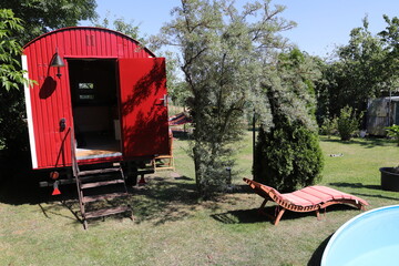 a red trailer with a lounger by the pool