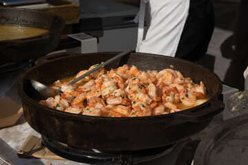 selective focus on a huge frying pan with shrimps. Sale at the street food market of sea food