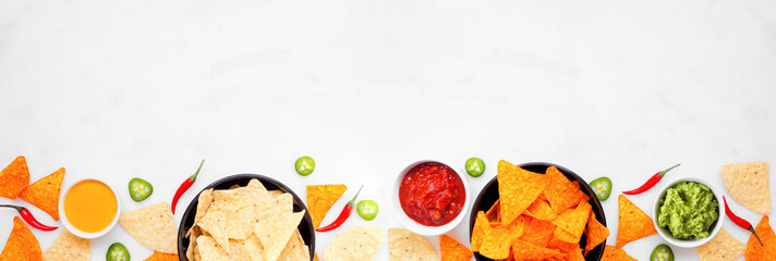 Nachos and dip bottom border. Top view on a white marble banner background. Copy space.