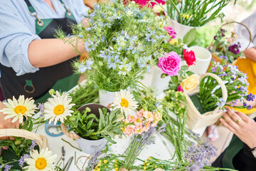 Master class on making bouquets. Spring bouquet in wicker basket. Learning flower arranging, making...