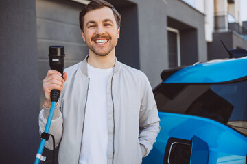 Man holding charger from electric car