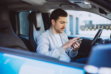 Business man sitting in his electric car