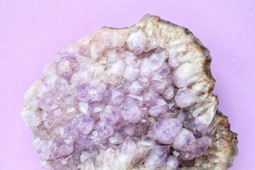 Violet amethyst gemstone crystal mineral on purple background with copy space. Natural stone....