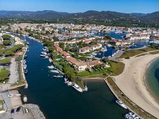 Fototapeta premium Arial view on blue water of Gulf of Saint-Tropez, boats, houses in Port Grimaud and Port Cogolin, villages on Mediterranean sea with yacht harbour, Provence, summer vacation in France