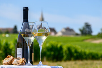 Glasses of white wine from vineyards of Pouilly-Fume appelation and example of flint pebbles soil,...