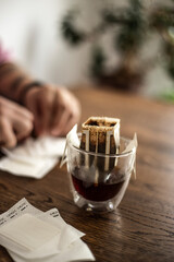 black coffee is brewed in a drip bag on a wooden table. black coffee. drip packs.