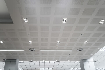 Ceiling mounted cassette type air conditioner and modern lamp light on white ceiling. Duct air...