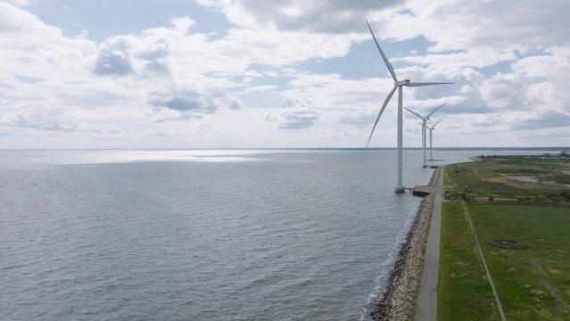Aerial view of the wind turbines. Green ecological power energy generation. Wind farm eco field. Offshore and onshore windmill farm green energy at sea. Offshore wind turbines on the coast of Copenhag