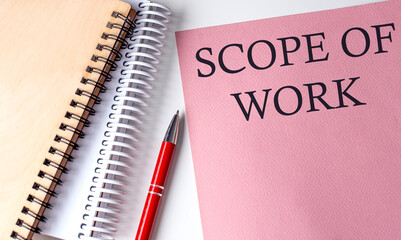 SCOPE OF WORK word on the pink paper with office tools on white background