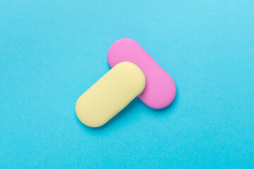 Colorful erasers on color backgroung, top view