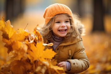 Adorable happy little girl playing with maple leaves in autumn park