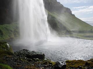 Seljalandsfoss, a waterfall in Iceland flowing into the dark stream