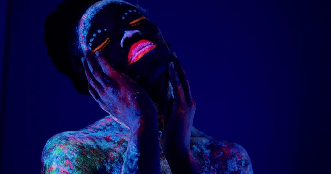 young woman with uv makeup colors which glow under black light Slow motion