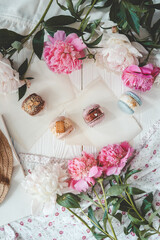 Macaroons and peonies, flat lay top view