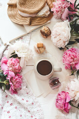 Cup of tea, macaroons and peonies, flat lay top view. good morning concept