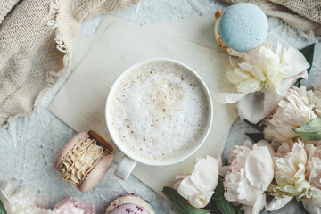 Fototapeta na wymiar Cup of coffee, sweet macaroons and white peonies, beautiful aesthetic photo