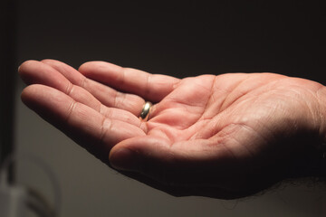 Male hand with marriage ring open upwards