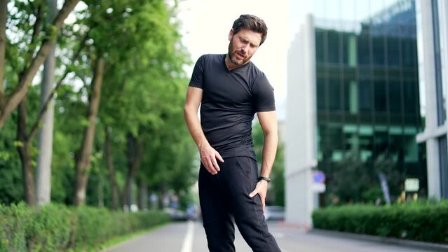 Athletic man massages a sprained leg injury during a workout run outdoor. Mature runner with muscle pain, trauma while jogging Fitness male sprain severe stretch pull. Leg muscle cramp calf sport