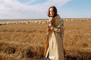 Stylish young woman posing in a field. Fashion, glamour, lifestyle concept. Autumn.