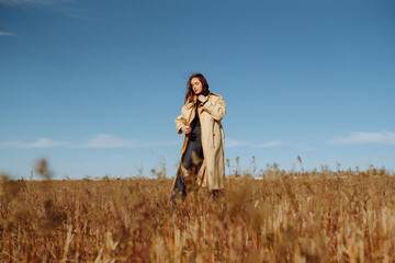 Stylish young woman posing in a field. Fashion, glamour, lifestyle concept. Autumn.