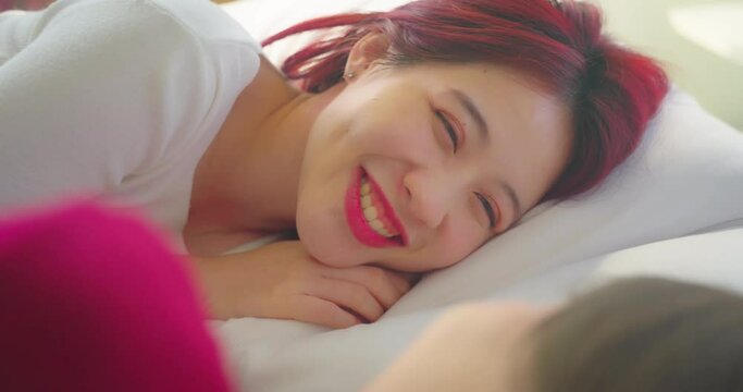 Portrait of couple lesbian in bed room. They sleeping together in bedroom with smiling.