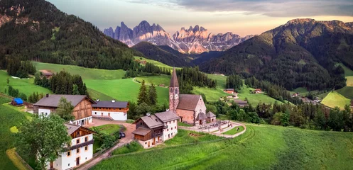 Poster Stunning Alpine scenery of breathtaking Dolomites rocks mountains in Italian Alps, South Tyrol, Italy. Aerial view of Val di Funes and village Santa Maddalena, Valley Isarco © Freesurf