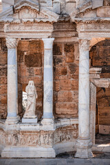 Obraz premium Remains of a large amphitheater in the ancient city of Hierapolis near Pamukkale, Denizli. Frescoes on the wall, columns, ancient Greek writings and a statue of a woman