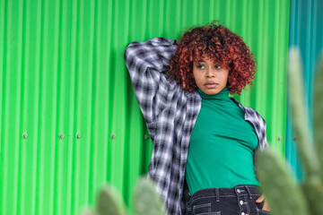 casual style girl leaning on the green wall on the street