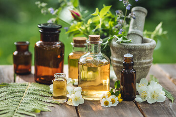 Assortment of organic essential oils, herbal extracts and medical flowers herbs In glass bottles. Alternative therapy, aromatherapy. Natural ingredients in cosmetic and medicine.