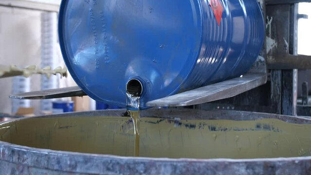 toxic flammable liquid pouring out of a blue barrel