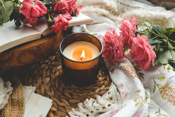 Burning candle, book and roses, aesthetic summer photo